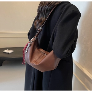 Detail of brown PU leather hobo bag featuring a unique red braided rope charm