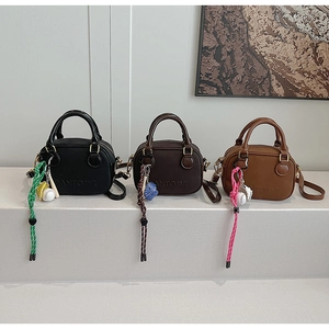 Détails de mini sacs à bandoulière en noir et marron avec des breloques de baseball