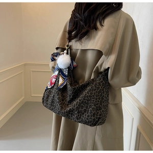 Sac fourre-tout léopard en toile avec foulard en soie et pompon porté à l'épaule