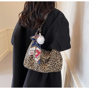 Détail du sac cabas léopard avec foulard décoratif et charm pompon blanc sur tissu souple