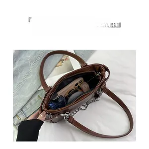 Interior view of brown leather bag showing large capacity for phone and perfume