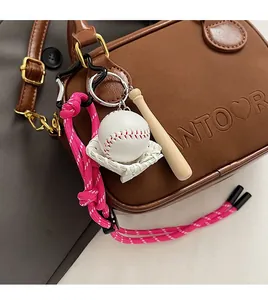 Vue macro d'un bijou de sac baseball avec cordon rose et mini batte sur sac en cuir