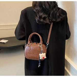 Sac à bandoulière vintage en cuir marron avec gaufrage de lettres et breloque peluche