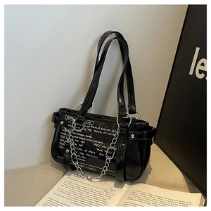 Detail of black patent leather handbag with white graffiti and silver chunky metal chain