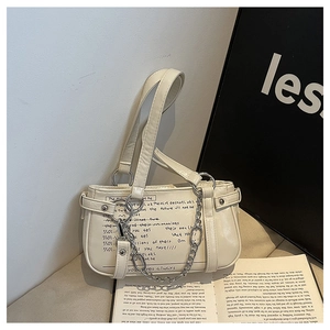 Close-up of creamy white PU leather bag with black graffiti print and silver chain link