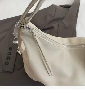 Gros plan sur le zip fluide d'un grand sac cabas en cuir PU souple blanc crème