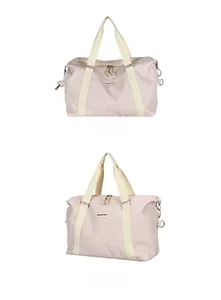 Detail of pink travel bag featuring textured fabric and durable reinforced handles