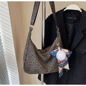Détail du sac cabas léopard avec ruban en soie bleue et breloque perle en peluche