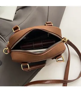 Vue de dessus de l'intérieur spacieux avec poche zippée de ce sac à main en cuir brun