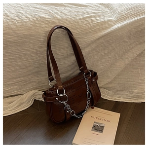 Detail of caramel brown PU leather bag with silver chain and adjustable shoulder strap