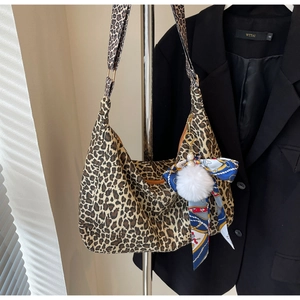 Gros plan détaillé du grand sac cabas léopard avec pompon en peluche et ruban décoratif