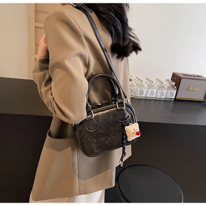 Détail du sac à main vintage en cuir PU noir avec lettres embossées et charm ours