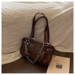 Close-up of vintage brown gloss shoulder bag with silver hardware and chain detail