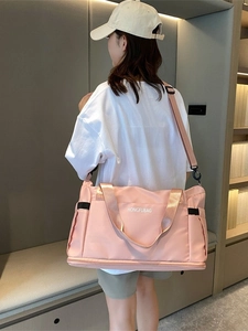 Pink large-capacity nylon travel bag with shoulder strap shown on model for travel