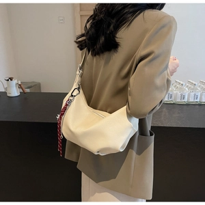 Woman wearing creamy white PU hobo bag with red checkered scarf and chain detail