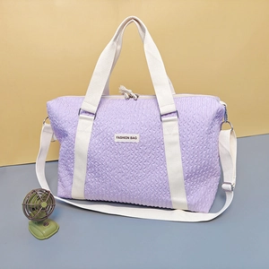 Detail of purple wavy texture travel bag with dual handles and adjustable shoulder strap