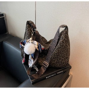 Détail du sac hobo léopard avec pompon blanc et pendentif en foulard de soie chic