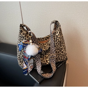 Détail du sac cabas léopard avec pompon en peluche et accessoire élégant en foulard de soie