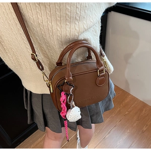 Détail du sac à main en similicuir marron avec logo ANTOOR et pendentif chat mignon