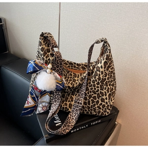 Détail du sac cabas imprimé léopard avec foulard en soie décoratif et pompon moelleux