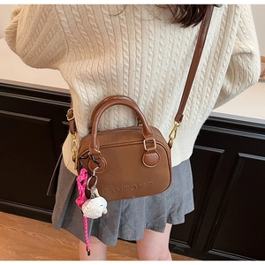 Close-up of vintage brown PU leather handbag with PANTOOR logo and cute cartoon charm