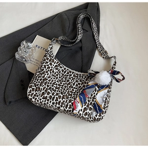 Détail du sac bandoulière léopard avec pompon en peluche et décoration de foulard en soie