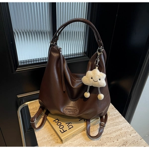 Détail d'un grand sac cabas marron en similicuir avec charm nuage en peluche et logo