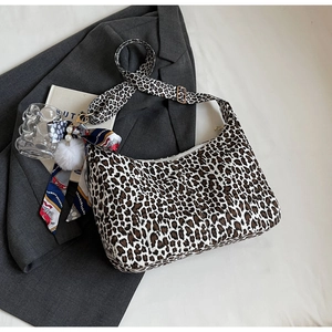 Détail du sac hobo à motif léopard avec pompon en peluche et décoration de foulard