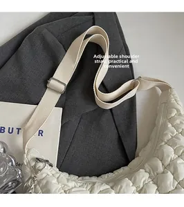 Vue détaillée du sac nuage blanc matelassé avec bandoulière ajustable et détails argentés