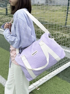 Large lavender quilted travel bag with white handles and fashion label for sports