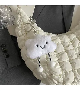 Détail d'un porte-clés nuage en peluche sur un sac matelassé au design sophistiqué