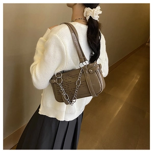 Detailed view of brown vintage shoulder bag with silver chain and text print