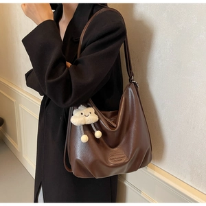 Détail du sac cabas en cuir marron foncé avec un charmant nuage en peluche douce