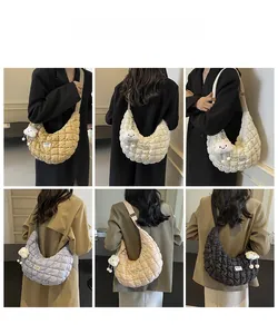 Sac bandoulière matelassé en forme de lune avec breloque nuage en peluche porté par mannequin