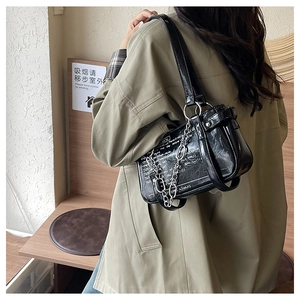 Detailed view of black underarm bag with white lettering and silver chain strap