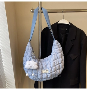 Détail du sac demi-lune matelassé bleu clair avec charme nuage et bandoulière large