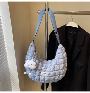 Détail du sac croissant matelassé bleu clair avec charme nuage blanc et bandoulière