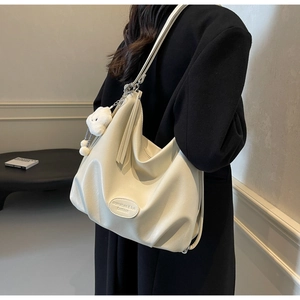 Détail du cabas plissé blanc crème avec bandoulière chaîne et breloque nuage