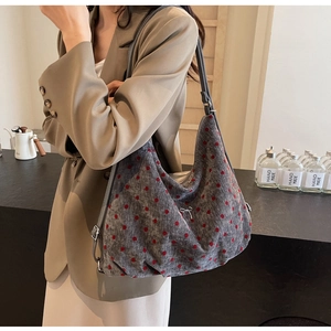 Close-up of grey polka dot hobo bag featuring a chic silver bow detail and leather strap