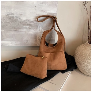 Close-up of brown suede hobo bag with matching pouch and vintage gold hardware