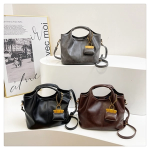 Detailed macro view of retro PU leather bucket bags in grey, black and mocha brown