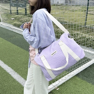 Light purple bubble textured travel duffel bag with white straps and adjustable shoulder belt