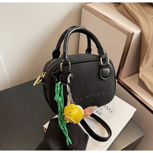 Detail of black leather mini handbag with ANTOOR embossed logo and colorful charm