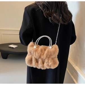 Detail of light brown faux fur cloudy handbag with rhinestone handles and pearl accents