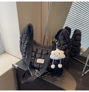 Détail du sac croissant noir matelassé avec bandoulière et pendentif nuage peluche