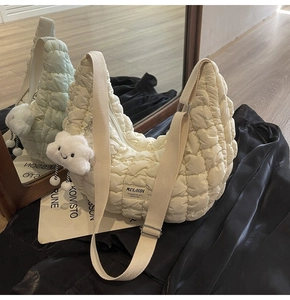 Détail du sac hobo matelassé blanc crème avec bandoulière et pendentif nuage