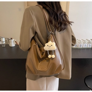 Détail d'un sac à bandoulière en cuir PU marron avec un joli porte-clé en peluche nuage blanc