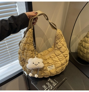 Détail du sac hobo matelassé avec bandoulière en toile et pendentif nuage en peluche