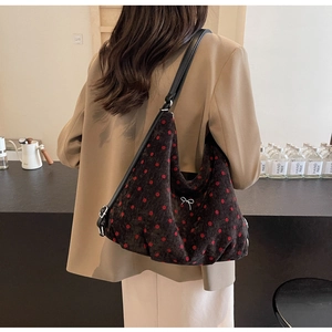 Close-up of a polka dot hobo bag with bow detail being worn over the shoulder