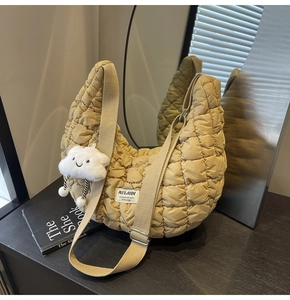 Gros plan du sac à bandoulière matelassé kaki avec bandoulière et breloque nuage